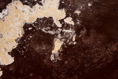 Koyu kahverengi alçı bir duvarın dokusu, kabuğu soyulmuş beyaz boyayla giyilmiş..