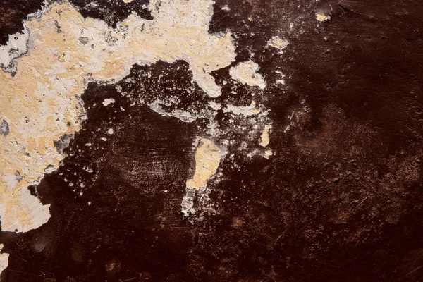 Koyu kahverengi alçı bir duvarın dokusu, kabuğu soyulmuş beyaz boyayla giyilmiş..