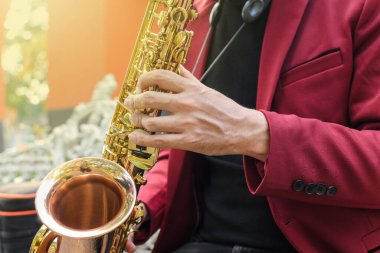 Açık havada altın saksafon çalan zarif bir müzisyen. Kapat..