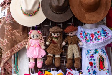 Markette satılık geleneksel el yapımı oyuncak bebek ve kıyafetlerin renkli bir gösterisi..