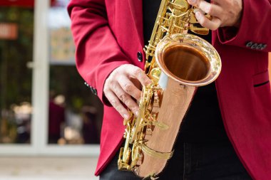 Açık havada altın saksafon çalan zarif bir müzisyen. Kapat..