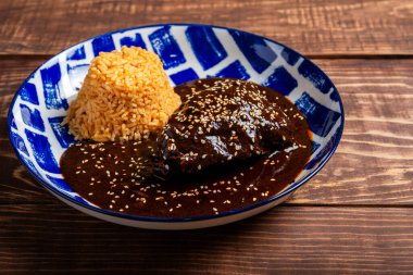 Ahşap bir masada servis edilen mavi ve beyaz desenli tabakta pirinçli tavuk köftesi tabağı..