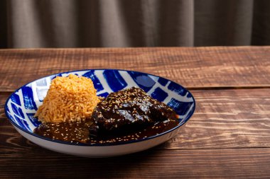 Ahşap bir masada servis edilen mavi ve beyaz desenli tabakta pilavlı tavuk köftesi..