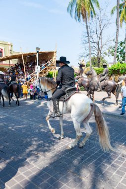 Colima, Colima, Meksika. 7 Şubat 2026: Geçit töreninde at süren kovboyların canlı ve şen bir sahnesi.