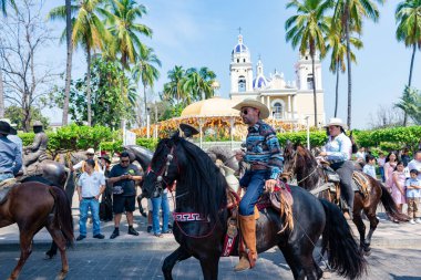 Colima, Colima, Meksika. 7 Şubat 2026: Geçit töreninde at süren kovboyların canlı ve şen bir sahnesi.