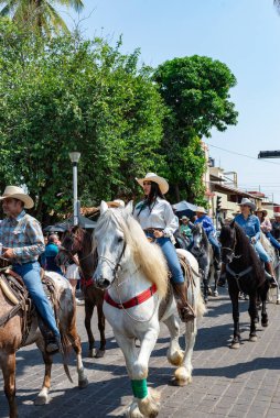 Colima, Colima, Meksika. 7 Şubat 2026: Geçit töreninde at süren kovboyların canlı ve şen bir sahnesi.