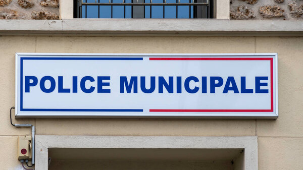 Sign saying "Local Police" (Police Municipale) written in French on the facade of the local police station building