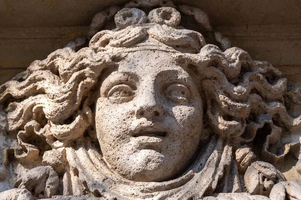 Taşa oyulmuş bir kadın yüzü, muhtemelen bir talih alegorisi, Fransa, Paris 'teki eski bir binanın dış görünüşü.