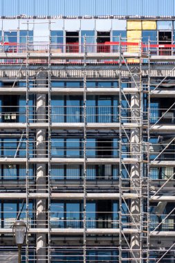İşçiler olmadan iskele bir ofis binasının ön cephesine yerleştirildi. Emlak inşaatı ve yenileme konseptleri