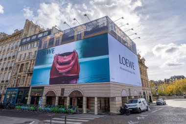 Paris, Fransa - 30 Ekim 2025: Büyük ilan panosunda bir Paris binasının ön cephesinde, İspanyol lüks moda evi Loewe 'den bir el çantası, yeni bir butiğin açılışı için reklam veriliyor.