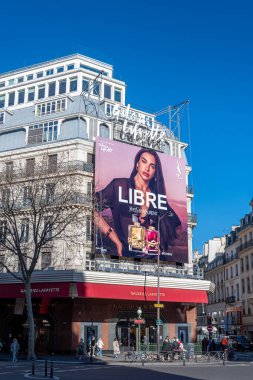 Paris, Fransa - 4 Şubat 2026: Fransa 'nın Paris şehrinin ünlü bir mağazası olan Galeries Lafayette' in cephesini kapsayan Yves Saint Laurent parfümü için büyük reklam panosu