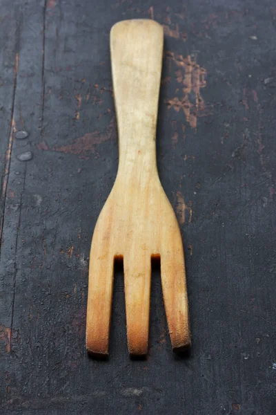 Tenedor de cocina de madera, en la vieja mesa negra enfoque selectivo de primer plano. estilo rústico. profundidad de campo poco profunda — Foto de Stock