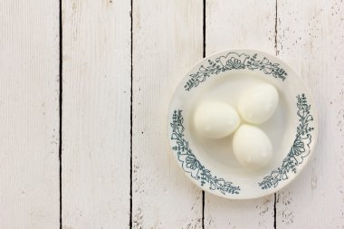 haşlanmış tavuk yumurta bir seramik tabak Beyaz ahşap zemin üzerinde kabuk olmadan. metin için ile yer