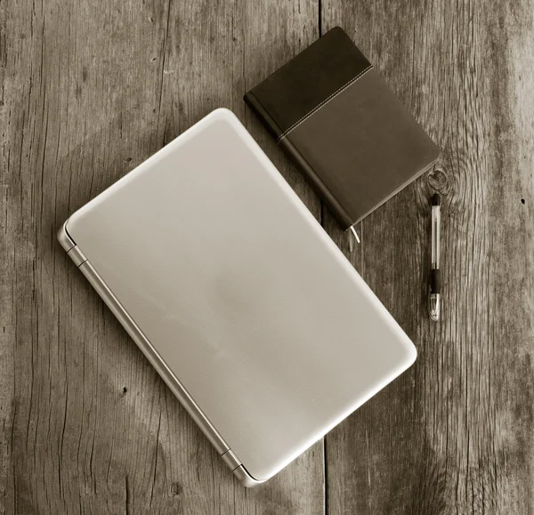 ラップトップ、ノートブック日記・古い納屋板のボールペン。黒と白の写真。平面図です。正方形の画像 — ストック写真