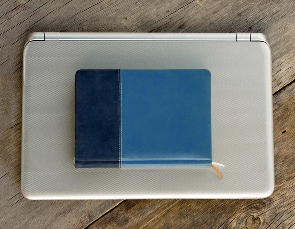 Pamiętnik niebieski notatnik na moim laptopie na stare deski zbliżenie — Zdjęcie stockowe