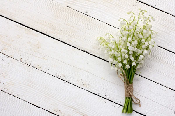 Konwalia bukiet białych kwiatów związany z ciąg na białym tle deski stodoły. z miejscem na zamieszczanie informacji — Zdjęcie stockowe