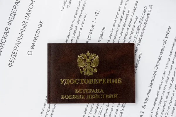 Weteran legitymacja na tle tekst prawa federalnego Federacji Rosyjskiej "o weteranów" — Zdjęcie stockowe