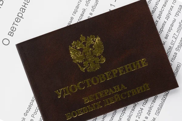 Veteran ID card on the background of the text of the federal law of the Russian Federation "About veterans" closeup — Stock Photo, Image