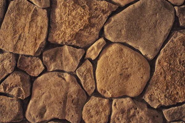 Textura de fondo de una pared forrada con piedra natural de cerca, foto tonificada — Foto de Stock