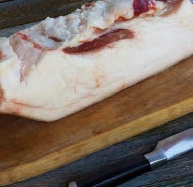 Çiğ domuz yağı bir kesme tahtası ve mutfak bıçak portre üzerinde büyük bir parçası