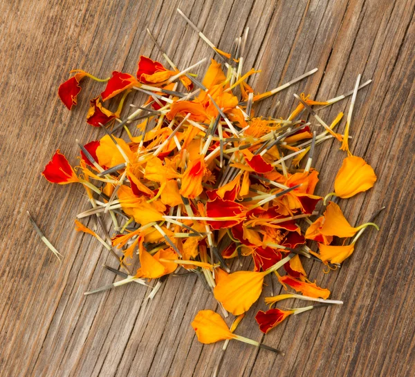 Een handvol Goudsbloem blaadjes verspreid op het oude bord in de scheuren. bovenaanzicht close-up — Stockfoto