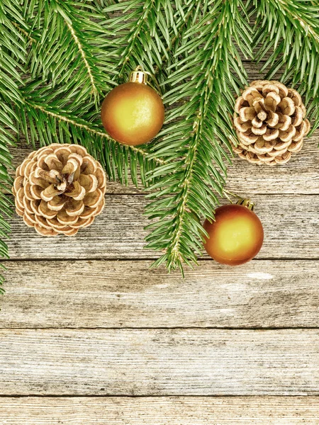 Latar belakang Tahun Baru atau Natal: cabang-cabang fir, bola kaca kemerahan kerucut di atas latar belakang kayu lama, tampilan atas, ruang fotokopi, foto berwarna — Stok Foto