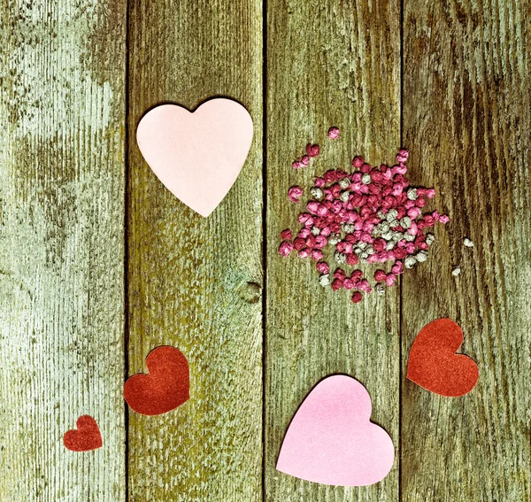 Cuori di carta rossi e rosa e palle su vecchie assi di legno grunge, vista dall'alto. Il concetto di amore, San Valentino . — Foto Stock