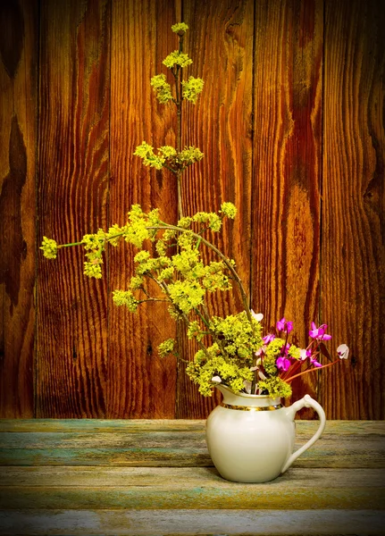 Rameaux florissants cornouiller et fleurs de cyclamen dans une cruche blanche. image avec vignette — Photo