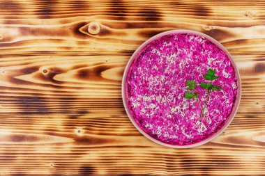 Geleneksel Rus bayram salatası. Kürk manto altında ringa balığı (shuba) ve ahşap arka plan manzaralı taze yeşil maydanoz.