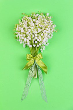 Yeşil arka plan manzaralı bir çiçek buketi ve kurdele. Yakın plan.