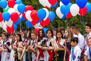 Maikop, Rusya - 22 Mayıs 2021: Rus okulundaki mezunlar için son çan resmi toplantısı, okul mezunları ellerinde renkli balonlarla okul bahçesinde
