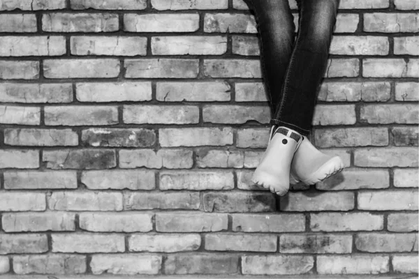 Crossed Legs Young Girl Jeans Orange Galoshes Sitting Brick Wall — Stock Photo, Image