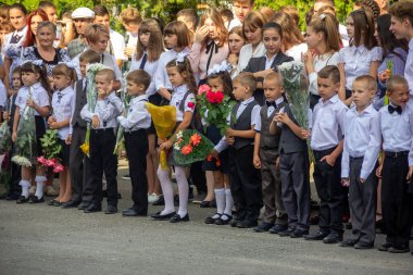 Adygea, Rusya - 1 Eylül 2019: Birinci sınıflar okulda çiçek buketleriyle bilgelik gününde resmi bir törenle