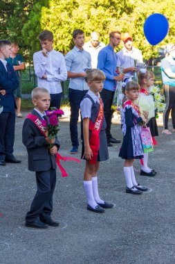 Adygea, Rusya - 1 Eylül 2020: Birinci sınıf öğrencileri ve balonlar ile okulda resmi bir tören düzenliyorlar.