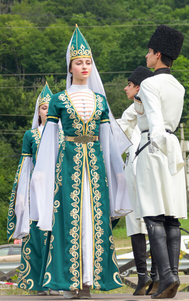 Young guys and girls dancers in traditional Adyghe dresses, dance at an ethnofestival in the Foothills of Caucasus in Adygea
