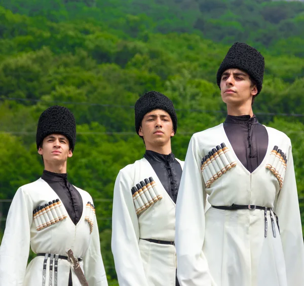 Jeunes hommes en costumes nationaux Adyghe dansant la danse traditionnelle lors d'un ethnofestival dans les contreforts du Caucase à Adygea — Photo