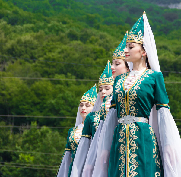 Young girls in Adyghe national costumes dancing traditional dance at an ethnofestival in the Foothills of Caucasus in Adygea