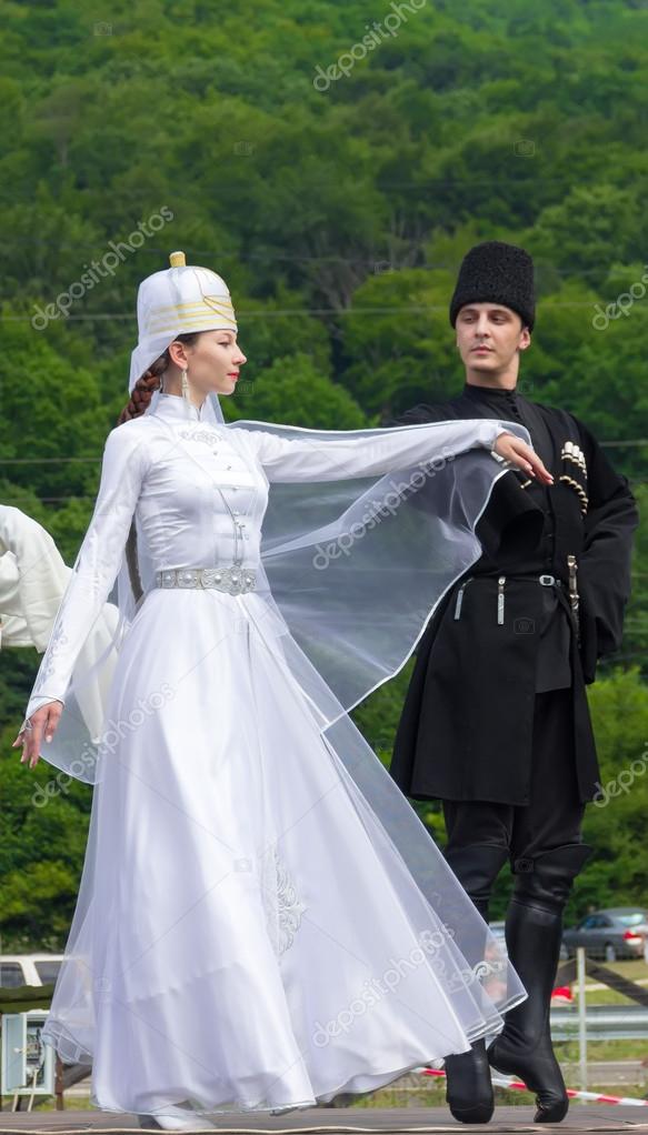 Young guy with a girl in Adyghe national costumes dancing traditional