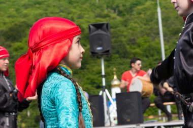 Olay, tapınak ve yeşil tepenin arka plan üzerinde geleneksel Hint elbiseli genç bir dansçı portresi. Adıge Batı Kafkasya eteklerinde etnik Festivali