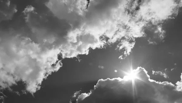 In the sky the sun breaks through the clouds. Black and white photo — Stock Photo, Image
