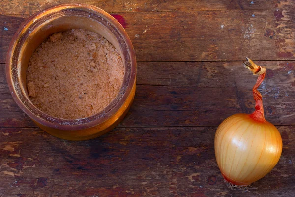 Head goldish lök och en burk Adygei salt på bordet från ladan styrelser. Kopiera utrymme. Ovanifrån. Rustik stil — Stockfoto