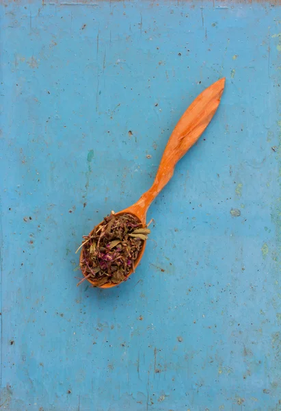 Erbe essiccate (Salvia officinalis) in un cucchiaio di legno sul vecchio sfondo blu. Ingrediente per cucinare bevande salutari. Il concetto di terapia erboristica rustica. Ingrediente per cucinare bevande salutari — Foto Stock