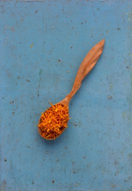 Kurutulmuş sarı yaprakları elması bir tahta kaşık eski mavi masada. Madde sağlıklı içecek yemek pişirmek için. Rustik bitkisel tedavi kavramı