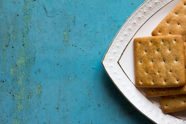 La parte triangular es placas de cerámica blanca de galletas saladas en el viejo fondo azul. Espacio libre para texto. Copiar espacio. Vista superior —  Fotos de Stock