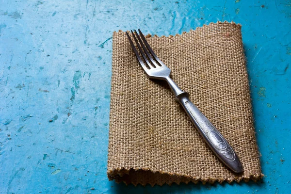 Gamla vintage gaffel på en linneservett på blå bakgrund. Ledigt utrymme för text. Kopiera utrymme. Ovanifrån — Stockfoto