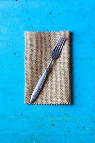 Gamla vintage gaffel på en linneservett på blå bakgrund. Ovanifrån — Stockfoto