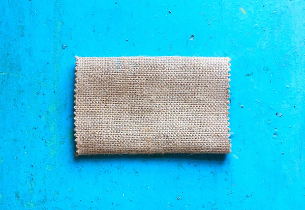 Burlap cloth on an old blue background. The view from the top. Rustic style. Free space for text. Copy space — Stock Photo, Image