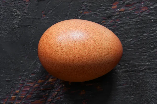 Uovo di pollo crudo marrone in guscio su vecchio sfondo di legno nero. primo piano, vista dall'alto — Foto Stock