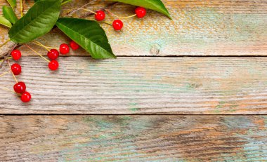 Şube kırmızı Olgun Kiraz eski ahır kurullarının bir arka plan üzerinde meyveleri. Uzay kopyalayın. Metin için boş alan