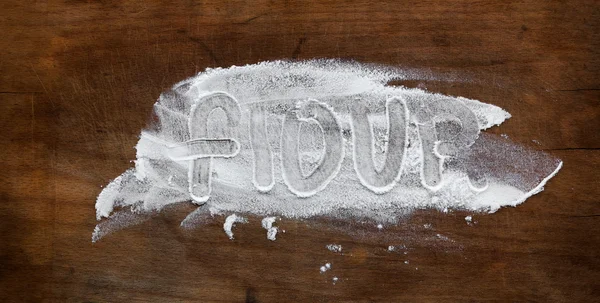 Old wooden cutting board with the word flour — Stock Photo, Image